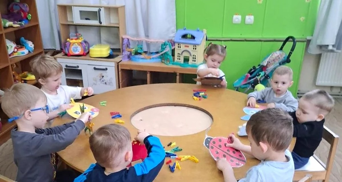 Дети занимаются творчеством за круглым столом в детском саду