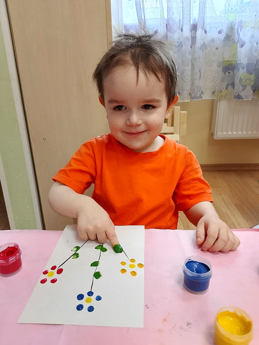 Улыбающийся ребёнок показывает поделку